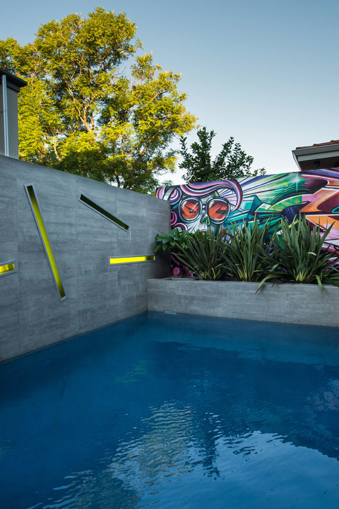 designer pool with graffiti wall and modern lighting